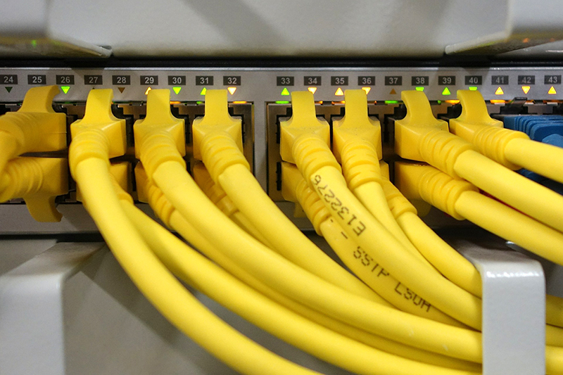 Netzwerktechnik – gelbe Netzwerkkabel an einem Patchpanel